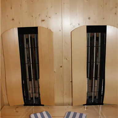 Two wooden benches are against a wall, with two towels in the middle. The room has a warm, inviting atmosphere.