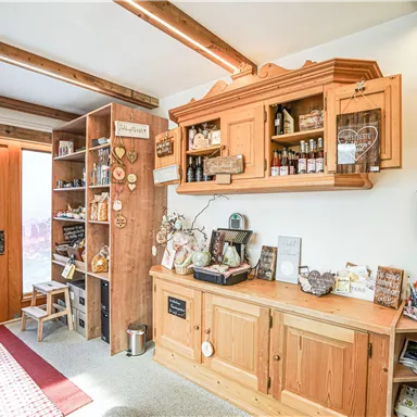 A cozy room with wooden shelves and a decorative window front. The table is filled with various treats and souvenirs.
