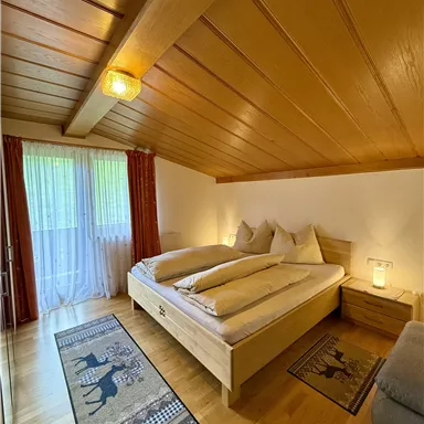 A cozy bedroom with a large bed and wooden floor.
Large windows let in plenty of light and create an inviting atmosphere.