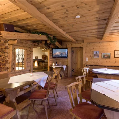 A cozy room with wooden furniture and rustic decor. A television is mounted on the wall and there is an atmosphere of warmth and coziness.