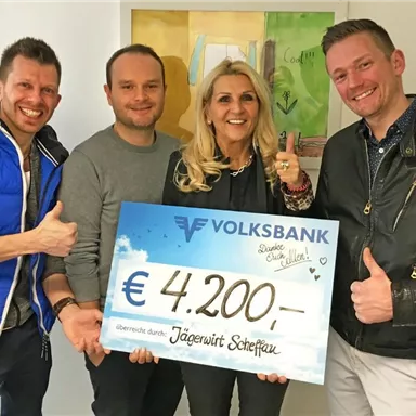 Vier Personen posieren lächelnd mit einem großen Scheck über 4.200 Euro von der Volksbank. Der Scheck wird zur Unterstützung einer Organisation oder eines Projekts überreicht.