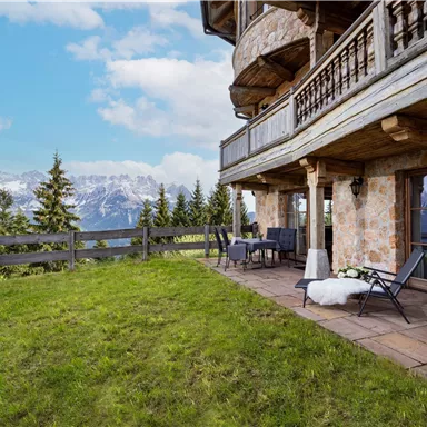 Ein gemütlicher Balkon mit Blick auf die Berge. Die Umgebung ist grün und die Atmosphäre ist entspannt.