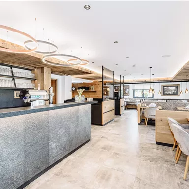 A modern restaurant with a stylish bar and elegant tables. The warm lighting creates an inviting atmosphere.