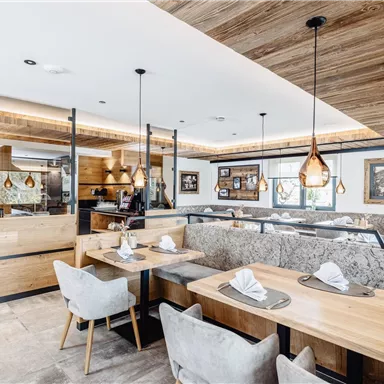 A modern restaurant with wooden-paneled walls and elegant dining tables. Soft lighting and stylish decorations create an inviting atmosphere.