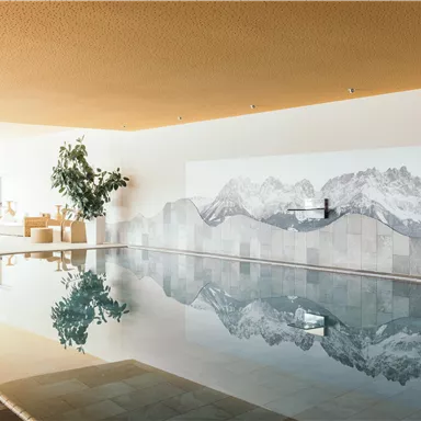 An elegant indoor pool with a mountain landscape in the background. The atmosphere is calm and relaxing, perfect for unwinding.