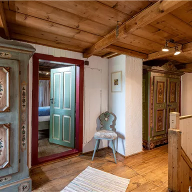 A cozy hallway with rustic wooden furniture and an open access to another room. The walls are designed to be friendly and inviting.