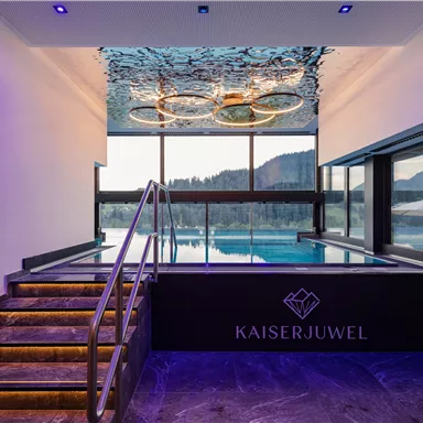 Ein modernes Schwimmbad mit schönem Ausblick auf die Berge. Die stilvolle Beleuchtung und das elegante Design schaffen eine entspannende Atmosphäre.