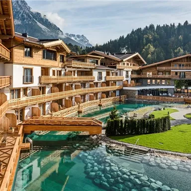 A beautiful resort with wooden balconies and a clear water pool. Surrounded by lush meadows and mountains, the property exudes tranquility and relaxation.