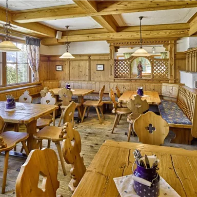 Ein gemütliches Restaurant mit Holzmöbeln und rustikalem Dekor. Die großen Fenster sorgen für viel Tageslicht in dem einladenden Raum.