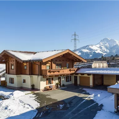 A beautiful chalet in the snow with mountains in the background. The clear sky and the surroundings give the place a calm atmosphere.