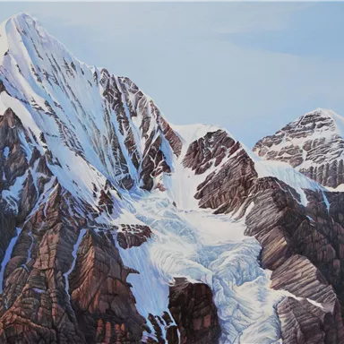 An impressive mountain range with snow-capped peaks and steep cliffs. The sky is clear, highlighting the majestic landscape.