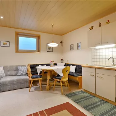 A cozy kitchen with a dining area and a sofa corner.
Walls in neutral colors and a light wooden floor create an inviting atmosphere.