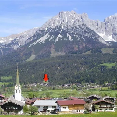 A picturesque alpine landscape with snow-capped mountains in the background. In the foreground, there is a village with a church and traditional chalets.