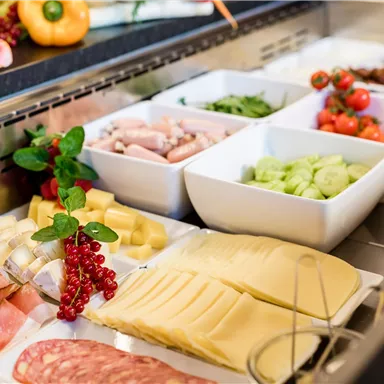 Eine reichhaltige Auswahl an Wurst, Käse und frischem Gemüse. Das Buffet bietet verschiedene Schalen mit Zutaten für kreative Snacks.