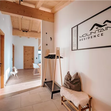 Ein heller Flur mit Holzdetails und einem modernen Design. An der Wand hängt ein Schild mit der Aufschrift "Mountain Residence".