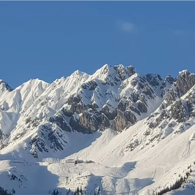 Snow-covered mountains under a clear blue sky. An impressive winter landscape.