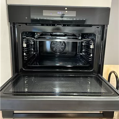 Ein moderner Backofen mit einem klaren Innenraum. Das Gerät hat eine digitale Anzeige und ist in einer eleganten schwarzen Farbe gehalten.