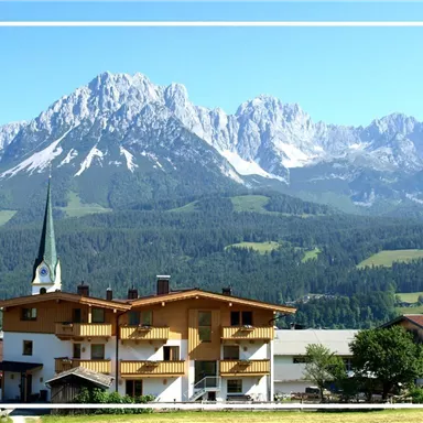 Ein malerisches Bergdorf mit traditionellen Häusern und einem Kirchturm. Im Hintergrund erheben sich majestätische Berge unter klarem blauen Himmel.