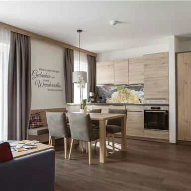 Eine gemütliche Wohnung mit einer modernen Küche und einem Essbereich. Helle Farben und Holzdetails schaffen eine einladende Atmosphäre.