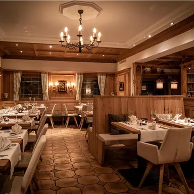A cozy restaurant with wooden decor and stylish tables. Warm lighting creates an inviting atmosphere.