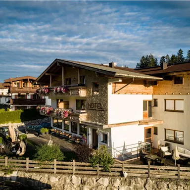 A charming hotel with traditional architecture and cozy balconies. Surrounded by a picturesque landscape and green plants.