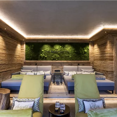 A cozy and modern relaxation space with wood paneling. Comfortable loungers and a green moss wall create a relaxing atmosphere.