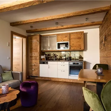 A cozy living kitchen with modern amenities and rustic wood decor. The room is bright and inviting, ideal for relaxation and guests.