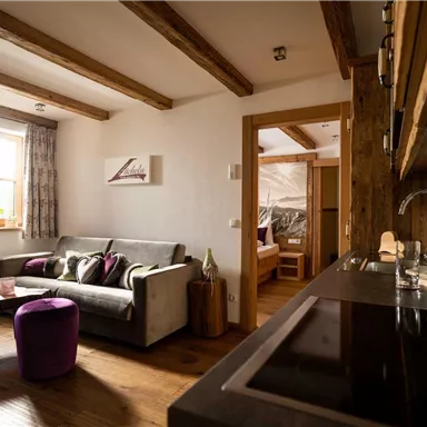 A cozy living kitchen with wooden details and a modern design. The room is brightly lit and invites relaxation.