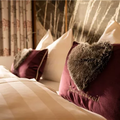 A cozy bedroom with two beds. On the heart-shaped pillows, it says "Warmth".