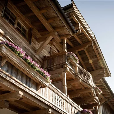 A traditional wooden house with balconies and flower boxes. The architecture radiates rural charm and coziness.
