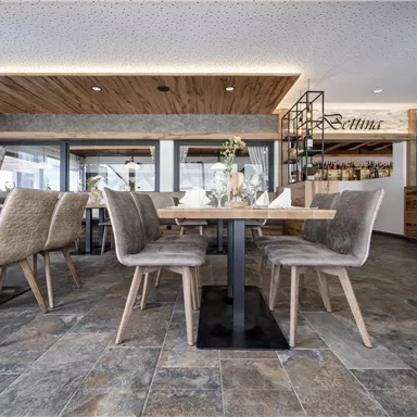 Ein modernes Restaurant mit Holzdekor und eleganten Tischen. Die Räume sind hell und einladend eingerichtet.