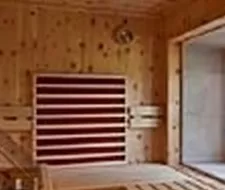 Eine gemütliche Sauna mit Holzwänden und Bänken. Die Atmosphäre ist ruhig und entspannend.