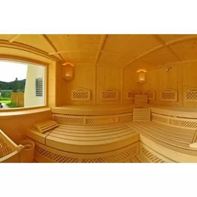 A cozy sauna made of light wood with an inviting interior. A green landscape can be seen through the window.