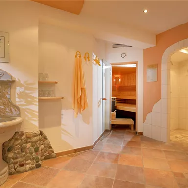 An elegant wellness area with a beautiful fountain and natural tiles. The atmosphere is relaxing and inviting, ideal for rest and wellness.