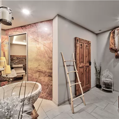 A modern bathroom with a freestanding bathtub and elegant tiles. There are wooden and plant accents that create a relaxed atmosphere.