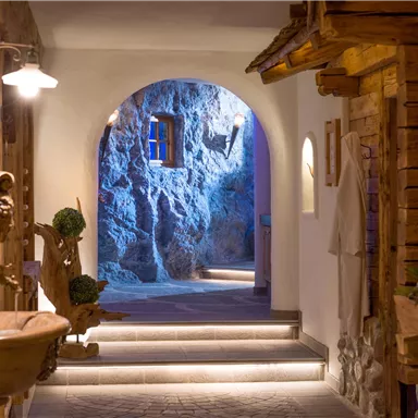 A cozy hallway with an arched entrance and soft lighting. Wooden details and natural elements are visible on the walls.