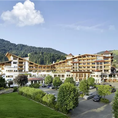 A modern hotel in a picturesque mountain landscape. Surrounded by trees and meadows, it offers a tranquil atmosphere.