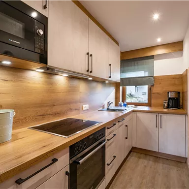 Eine moderne Küche mit Holzverkleidung und eleganten Geräten. Die Atmosphäre ist hell und einladend.