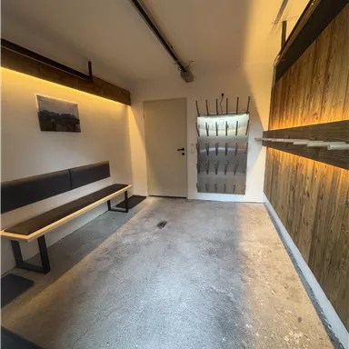 A modern entrance area with a bench and wooden walls. The lighting creates a pleasant atmosphere.