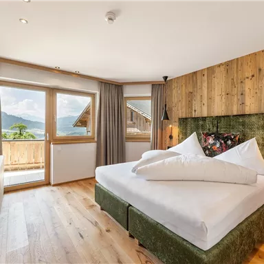 Living with a sense of nature: The lovingly furnished "Salven Suite" with ample wood, a large bed, and panoramic views combines coziness and design.