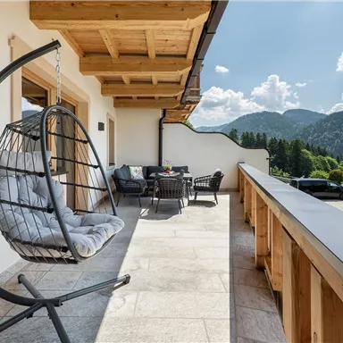 Here it is easy to live: The spacious balcony with hanging loungers and a lounge invites you to dream - with a view of the impressive Tyrolean mountain backdrop.