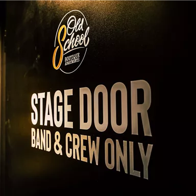 A black wall with a sign that says "STAGE DOOR." It is only accessible to the band and crew.