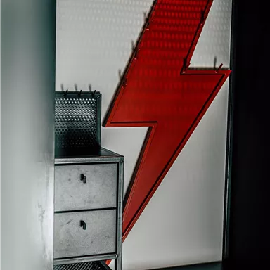 A modern wardrobe with a red lightning graphic. Below are two drawers and a shelf.
