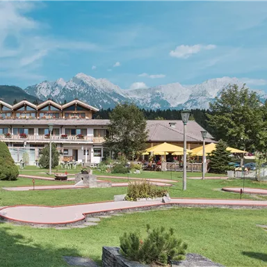 Ein schönes Hotel in einer ruhigen Umgebung mit Blick auf die Berge. Der Gartenbereich hat eine Minigolf-Anlage und viel Grünfläche.