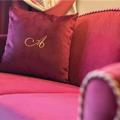 Love for detail: The logo cushion in the elegant upholstered chair charmingly expresses the handwriting of the house.