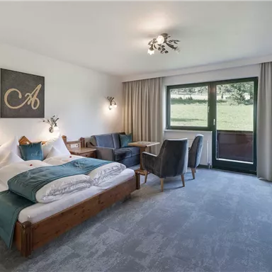 A comfortable room with a large double bed and a beautiful view outside. The decor is modern and inviting.