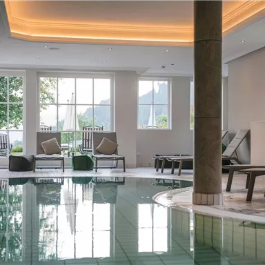 A bright wellness area with a pool and loungers. Large windows provide plenty of daylight and a relaxed atmosphere.