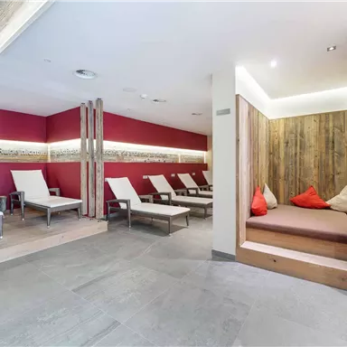 A serene wellness area with loungers and cozy seating. The walls are in warm colors, creating a relaxing atmosphere.