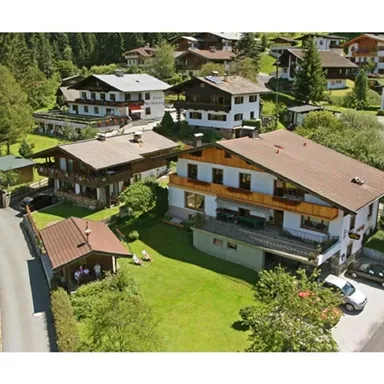 Eine malerische alpine Landschaft mit traditionellen Chalets und üppigem Grün. Die Umgebung ist ruhig und einladend, ideal für einen Erholungsurlaub.