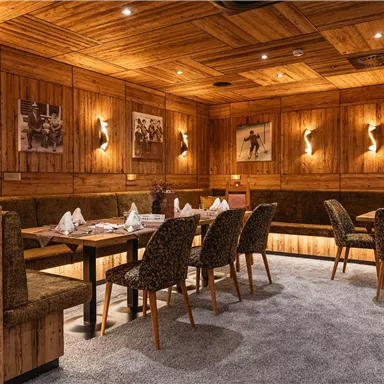 Ein gemütliches Restaurant mit holzvertäfelten Wänden und stilvollen Sitzecken. Die Beleuchtung ist warm und einladend, ideal für entspannte Mahlzeiten.